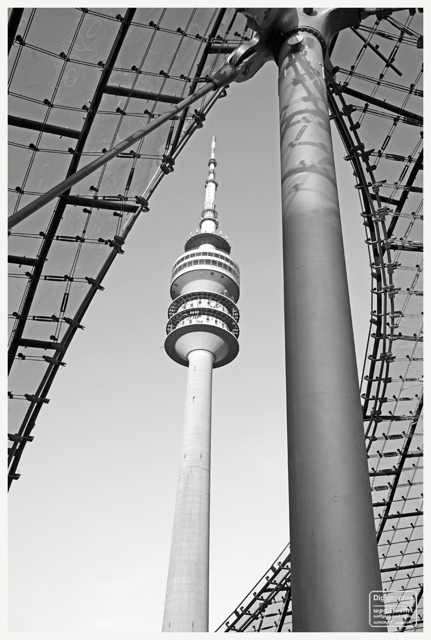 FineArt-Poster und Digigraphie (111): Ein Schwarz-Weiß-Foto mit dem Olympiaturm München, aufgenommen aus einer Perspektive , als würde sich das Dach des Olympiaturmes darüber spannen.